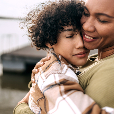 A woman hugging an adolescent child