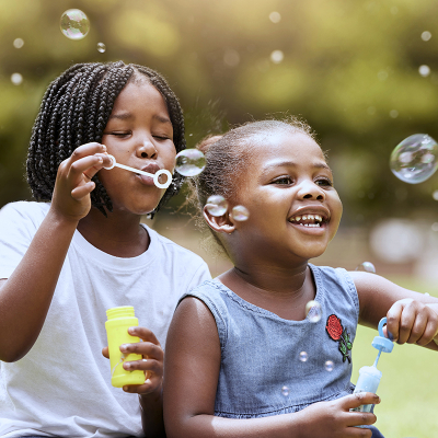 Kids blowing bubbles outside