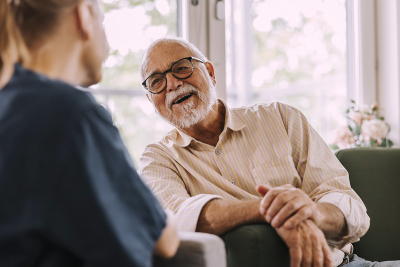 An elderly man talking to a health care provider
